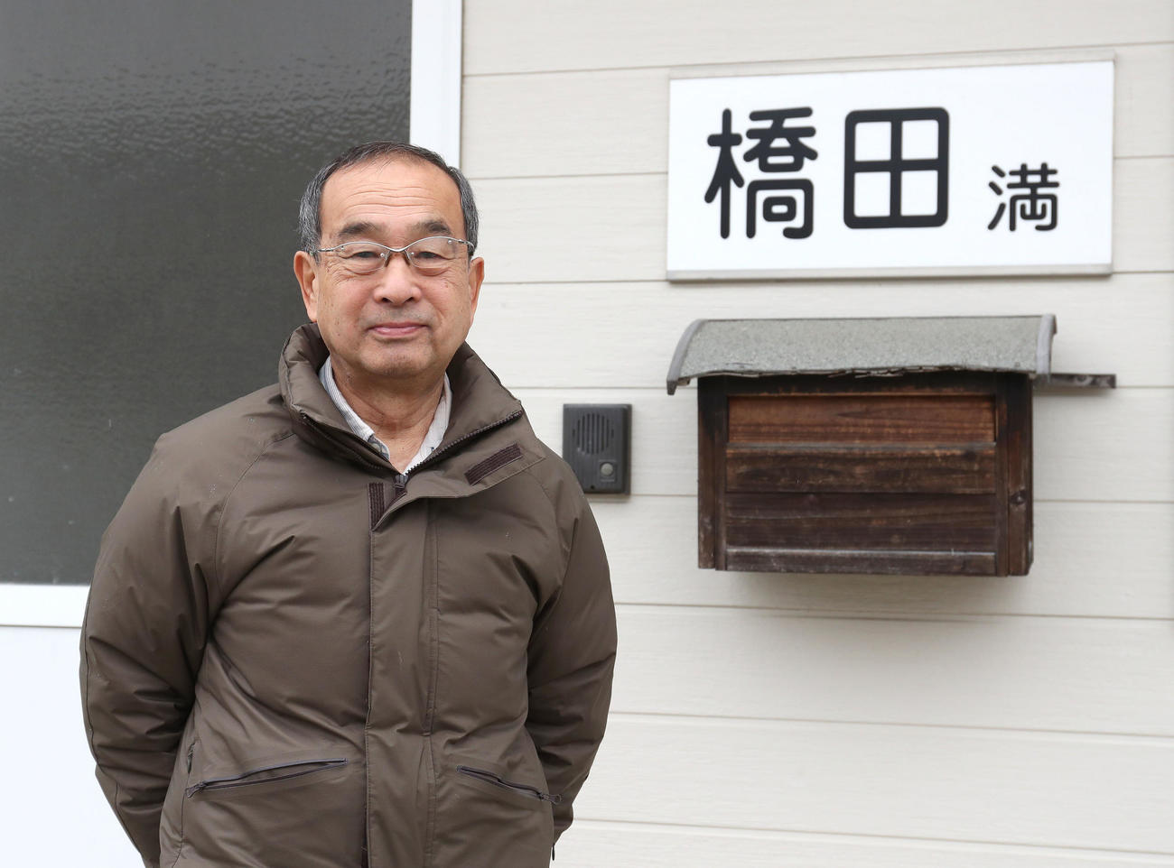看板の前で笑顔を見せる橋田師（撮影・白石智彦）