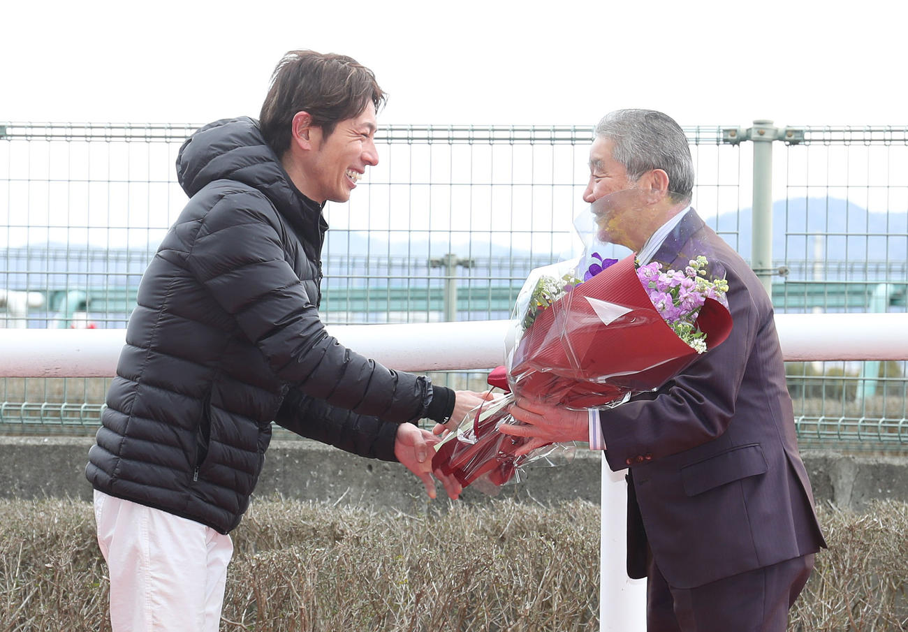 引退セレモニーで和田竜騎手（左）と握手を交わす五十嵐師（撮影・白石智彦）