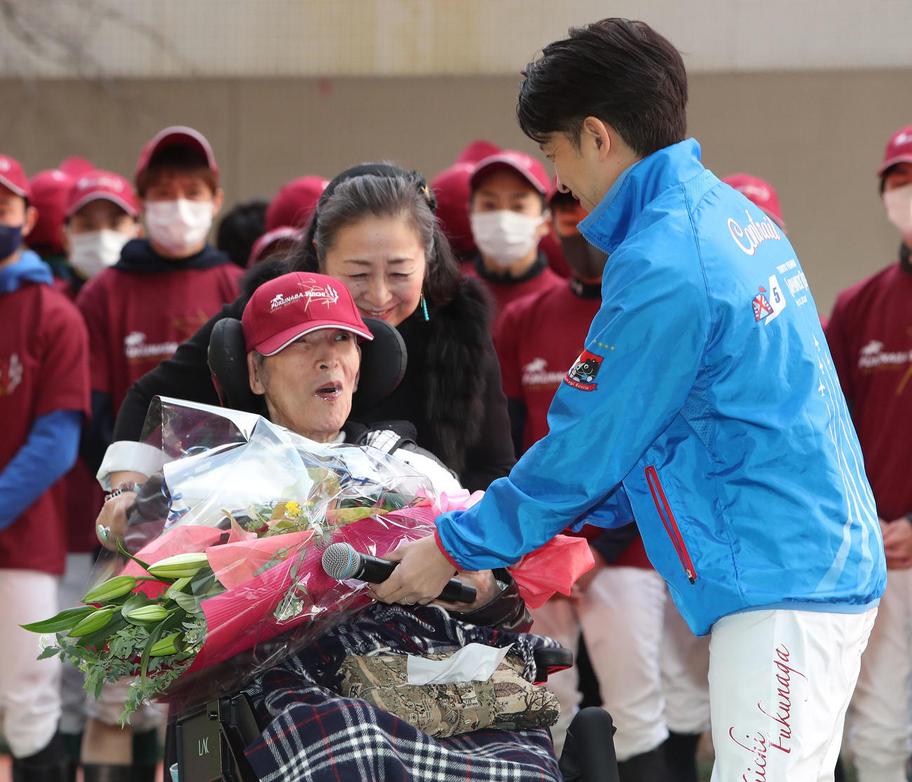 父の洋一さん（左）に花束を手渡す福永元騎手。中央は母の裕美子さん（撮影・白石智彦）