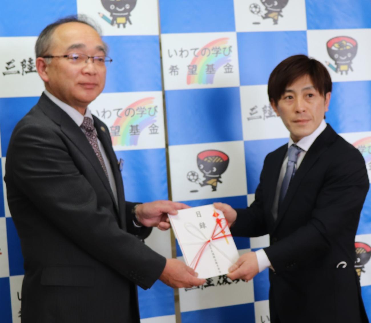 山本政騎手（右）が、佐藤教育委員会教育長に寄付金を贈呈した（岩手県競馬組合提供）