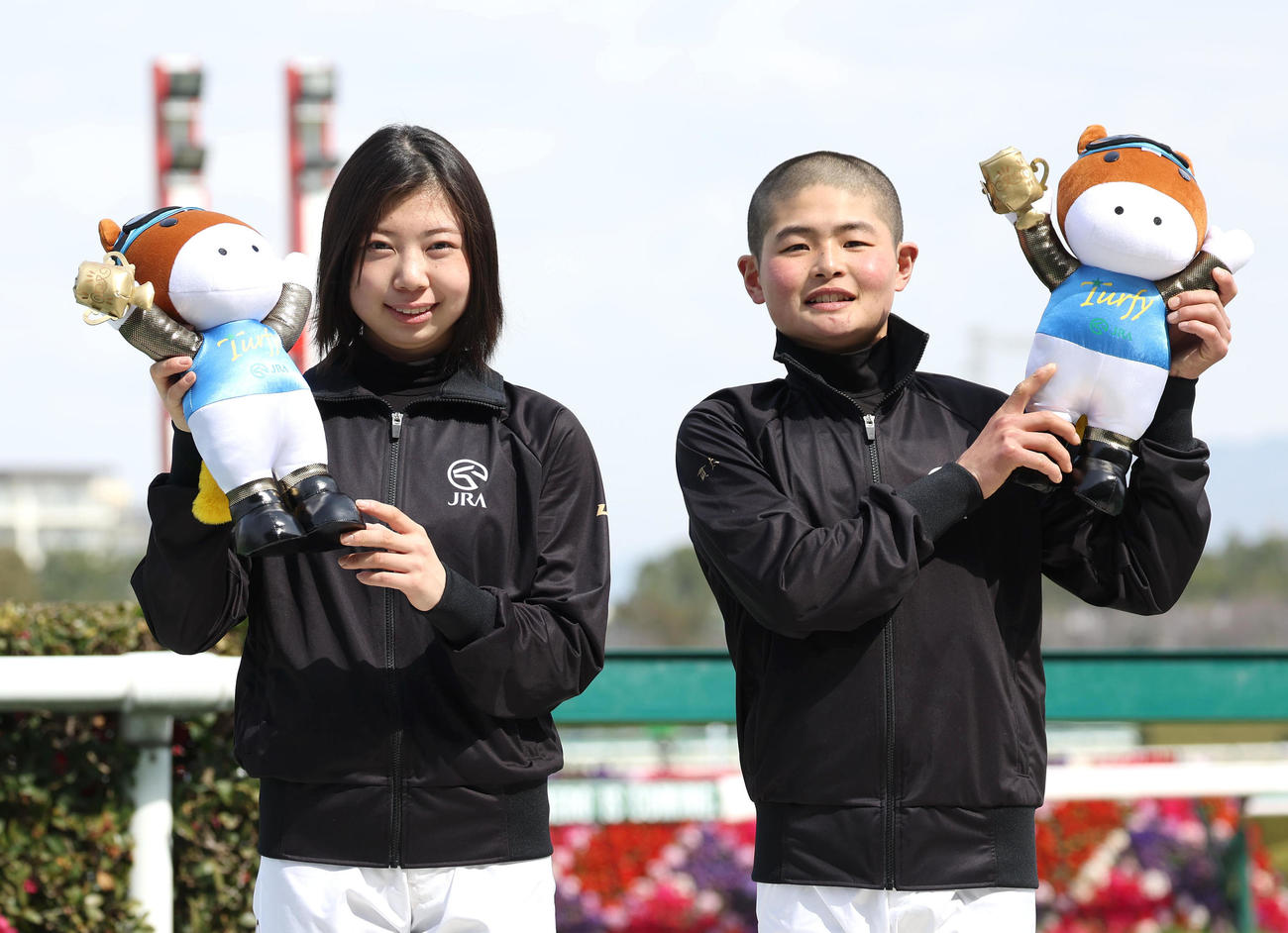 新人騎手紹介でターフィー人形を掲げる河原田騎手（左）と田口騎手（2023年2月26日撮影）