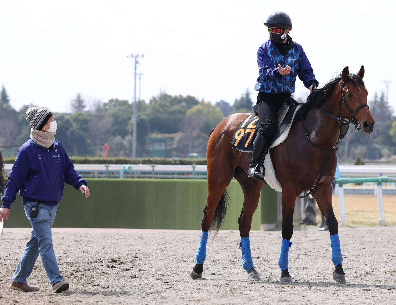 調教を終えて馬場を出るホウオウビスケッツ。左は奥村武師（撮影・丹羽敏通）
