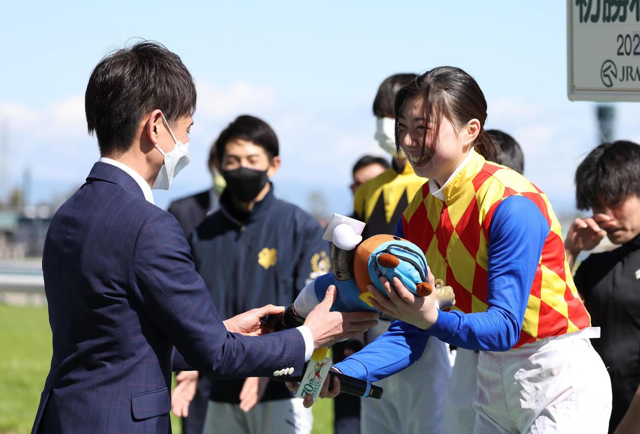 JRA初勝利を挙げ、師匠の渡辺師（左）から記念のターフィー人形を渡される河原田騎手（撮影・白石智彦）