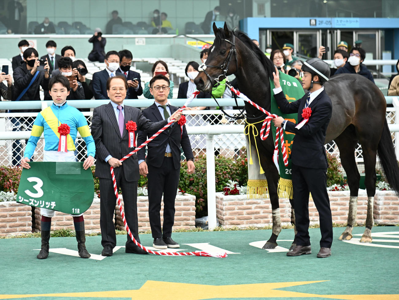 毎日杯を制し口取りするシーズンリッチ、角田騎手（左）、久保田調教師（左から3人目）（撮影・石井愛子）