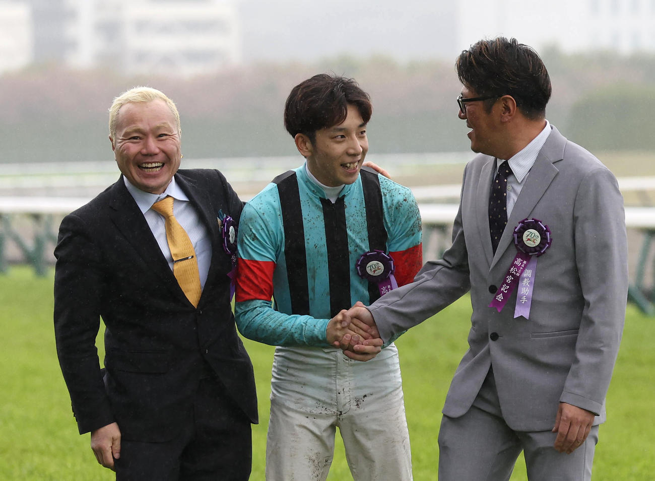 口取りを終えて関係者と握手を交わす団野騎手（中央）左は笑顔の西村師（撮影・白石智彦）