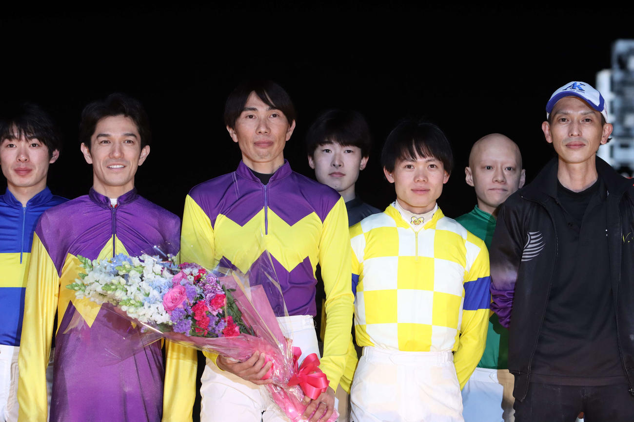 引退セレモニーで花束を受け取り記念撮影に納まる真島大輔騎手