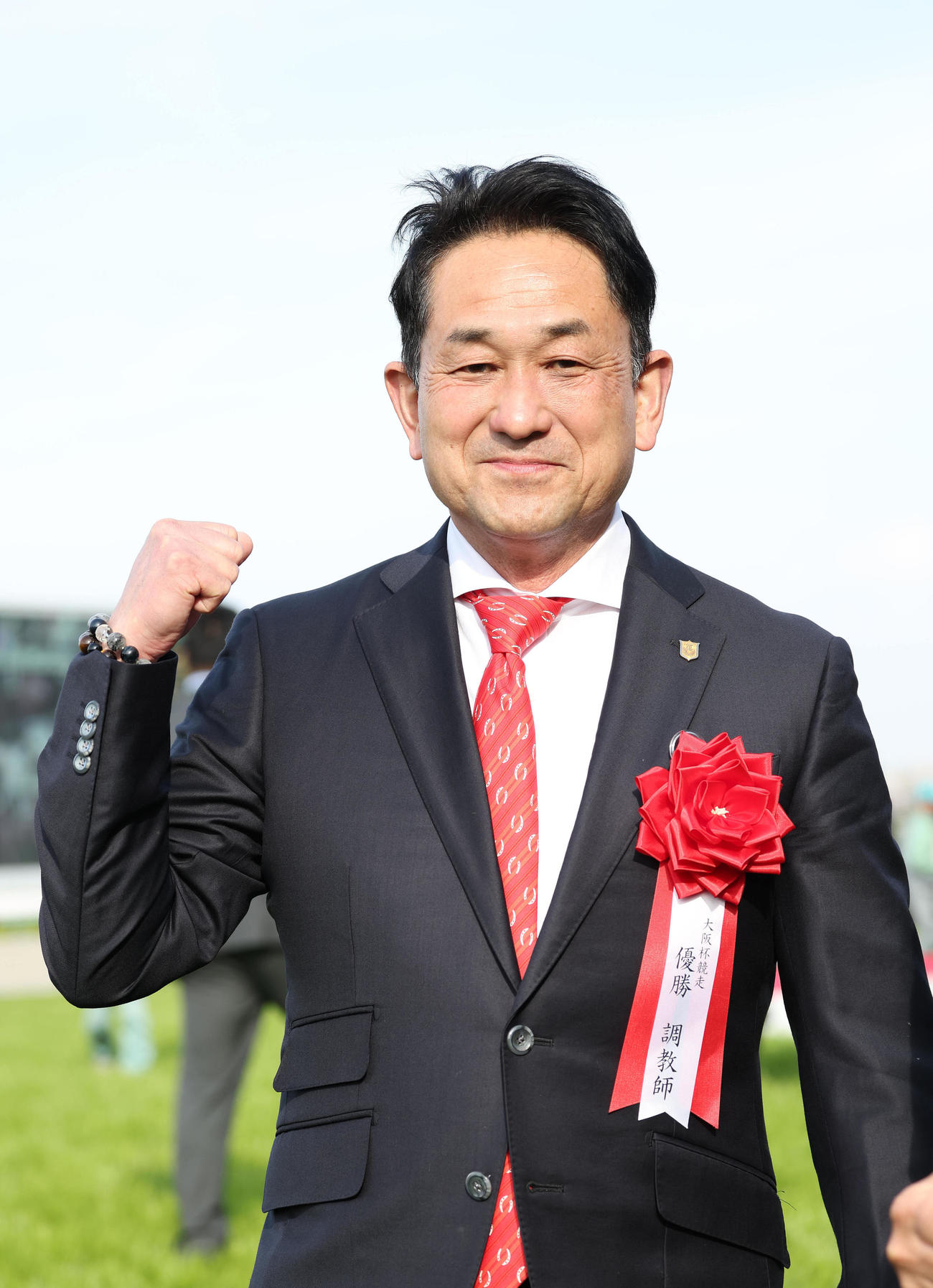 阪神11R、表彰式を終えて笑顔でガッツポーズする藤岡師（撮影・白石智彦）
