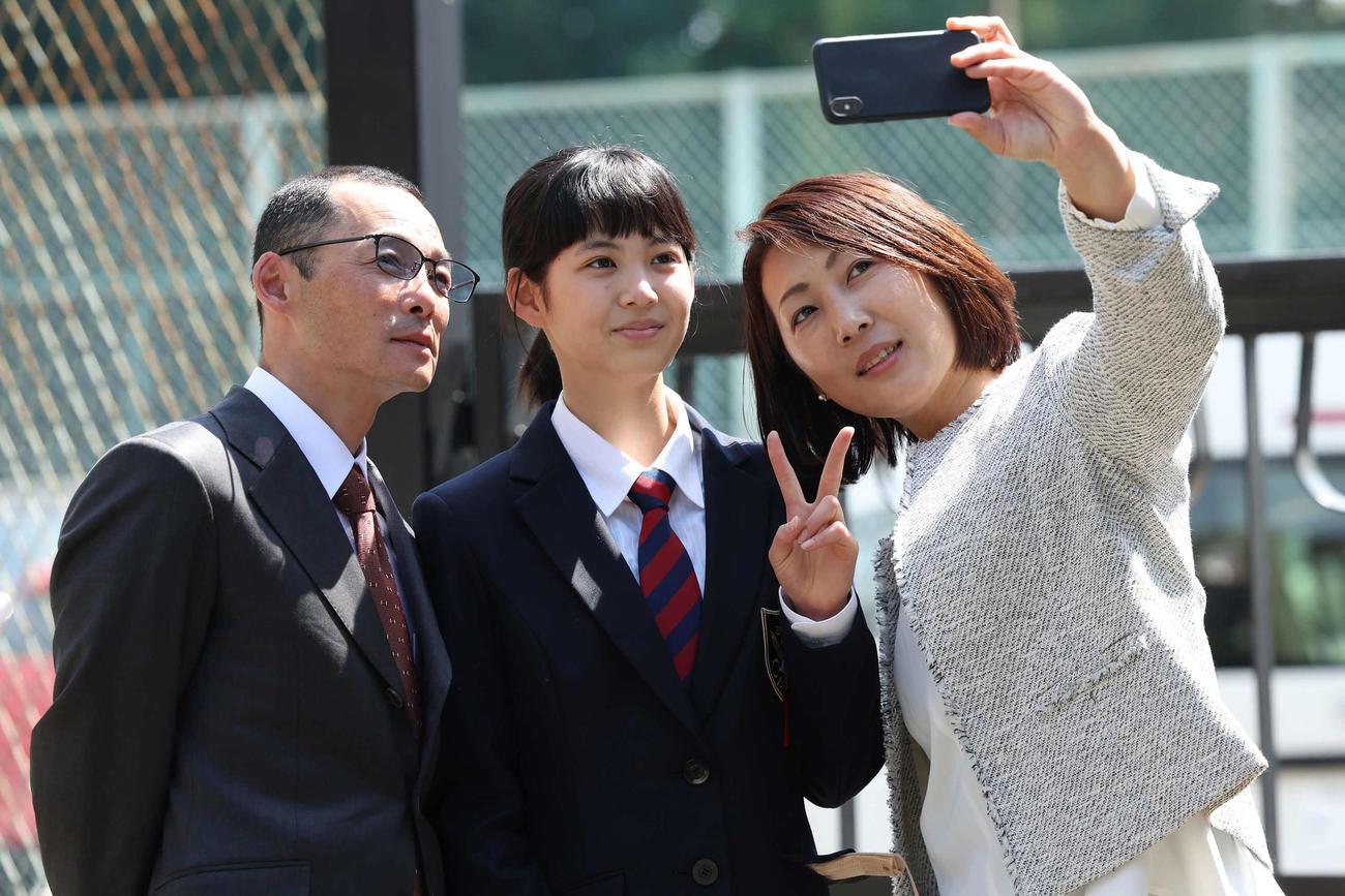 家族そろって記念撮影をする五十嵐ひなさん。左は父親の冬樹師、右は母親のめぐみさん（撮影・丹羽敏通）