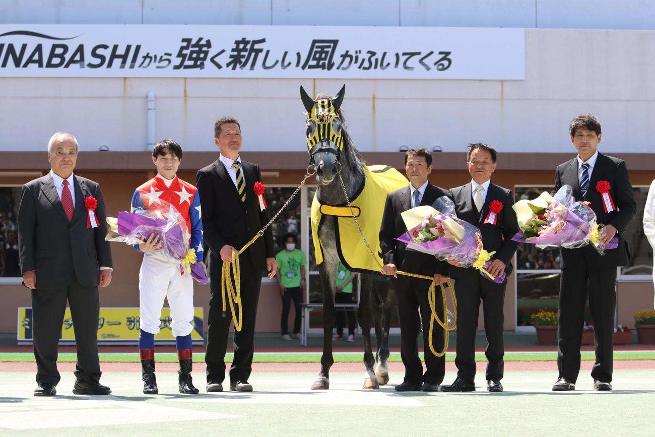 記念撮影に納まるミューチャリーと主戦の御神本騎手（左から2人目）、矢野義幸調教師（右から2人目）ら
