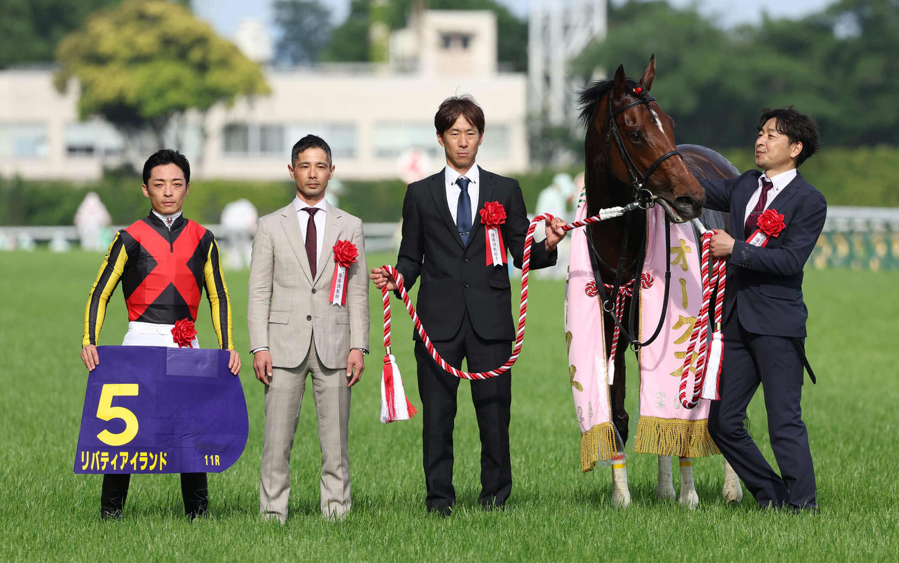 リバティアイランドの口取りをする川田騎手（左端）と中内田師（同2人目）（撮影・丹羽敏通）