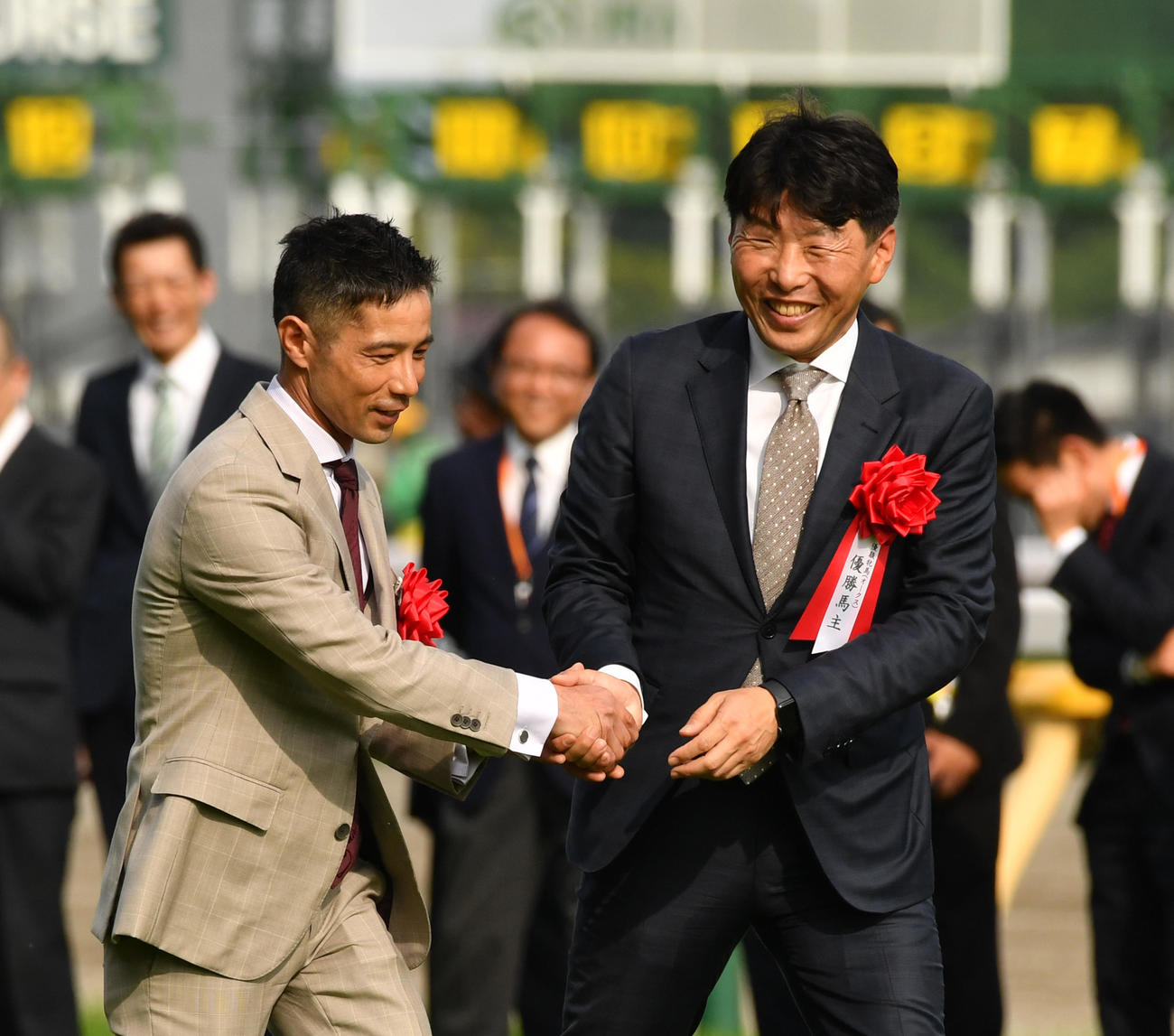 リバティアイランドの中内田調教師（左）は吉田サンデーレーシング代表と握手する（撮影・柴田隆二）
