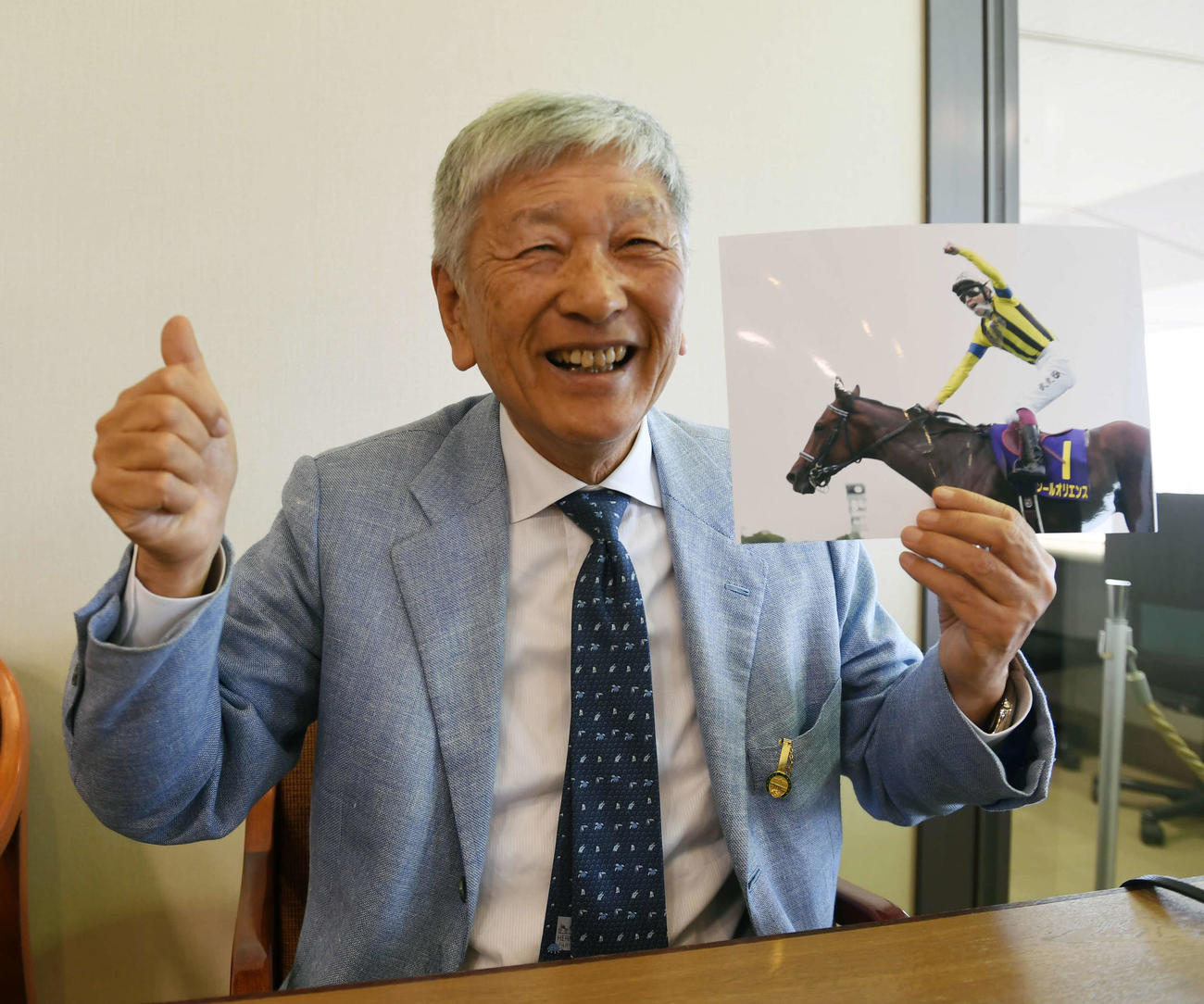 皐月賞優勝馬ソールオリエンスの写真を持つ吉田照哉社台ファーム代表（撮影・柴田隆二）