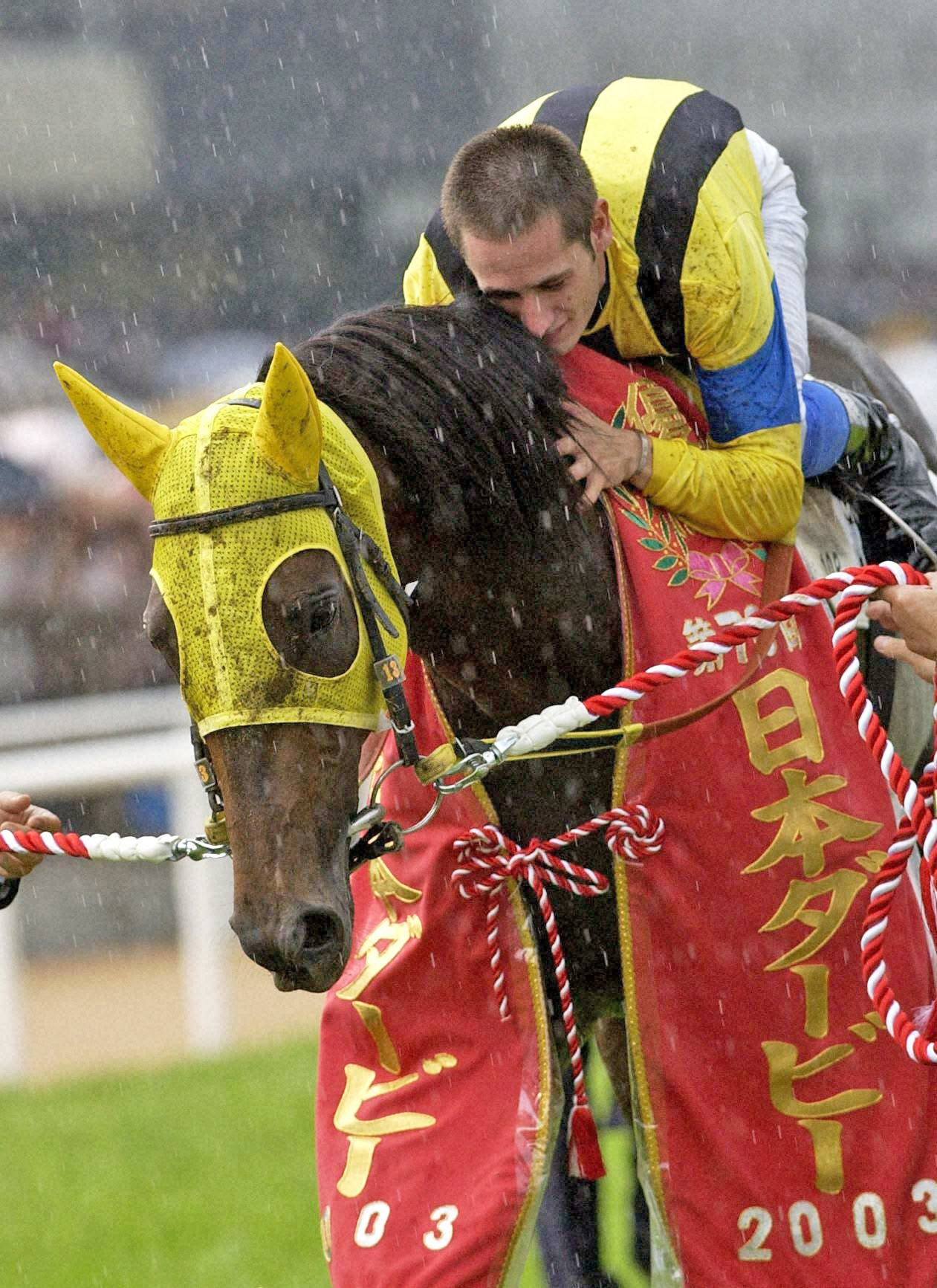 03年6月、ネオユニヴァースでダービーを制したミルコ・デムーロ騎手。愛馬に抱きつき感激に浸っていた