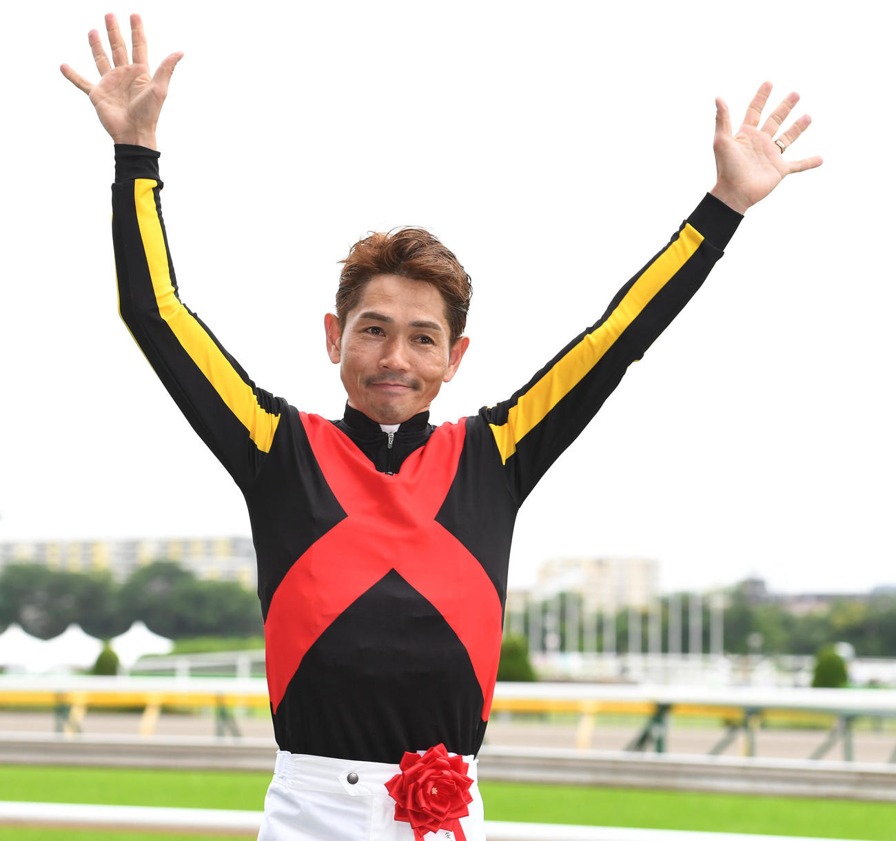 ソングラインで安田記念を制した戸崎騎手はお立ち台でバンザイする（撮影・柴田隆二）