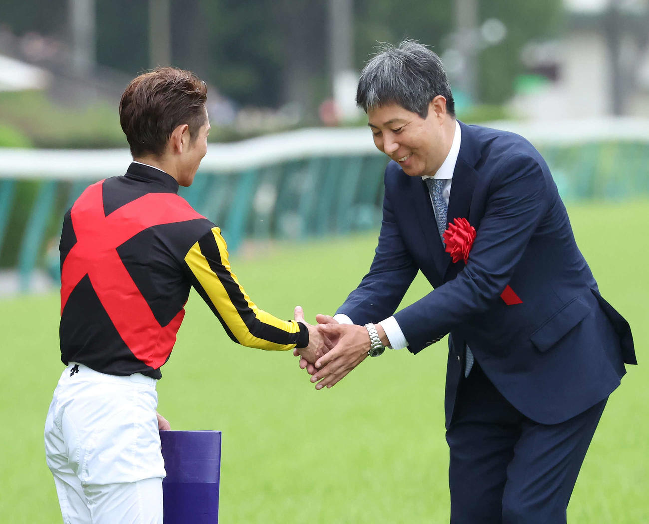 安田記念をソングラインで制して戸崎騎手（左）と握手する林師（撮影・丹羽敏通）
