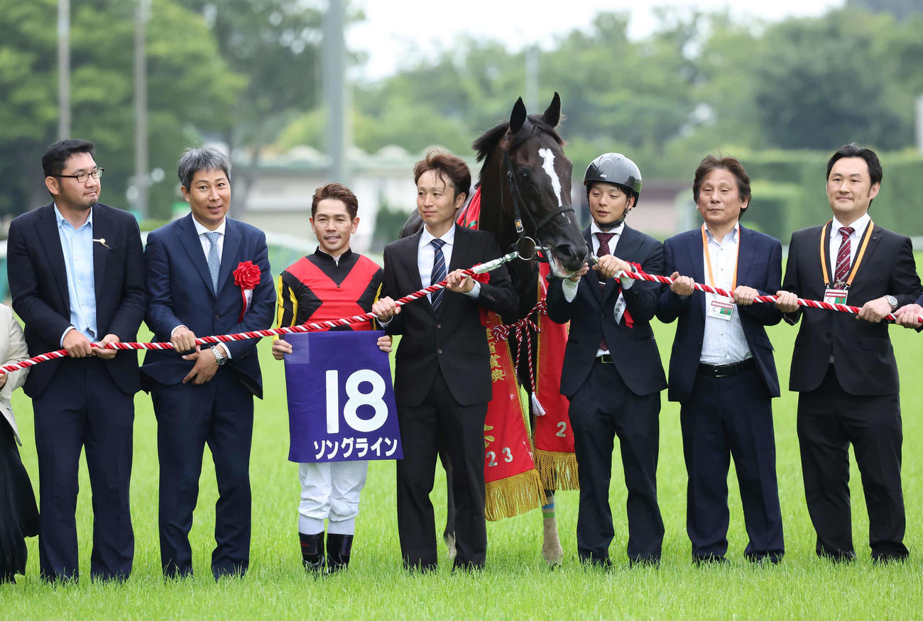 ソングラインの口取りをする林師（左から2人目）と戸崎騎手（撮影・丹羽敏通）