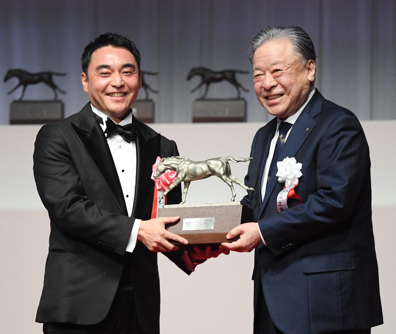 年度代表馬に選ばれたイクイノックスの米本シルクレーシング代表（左）は後藤JRA理事長からトロフィーを贈られた（2023年1月30日撮影）