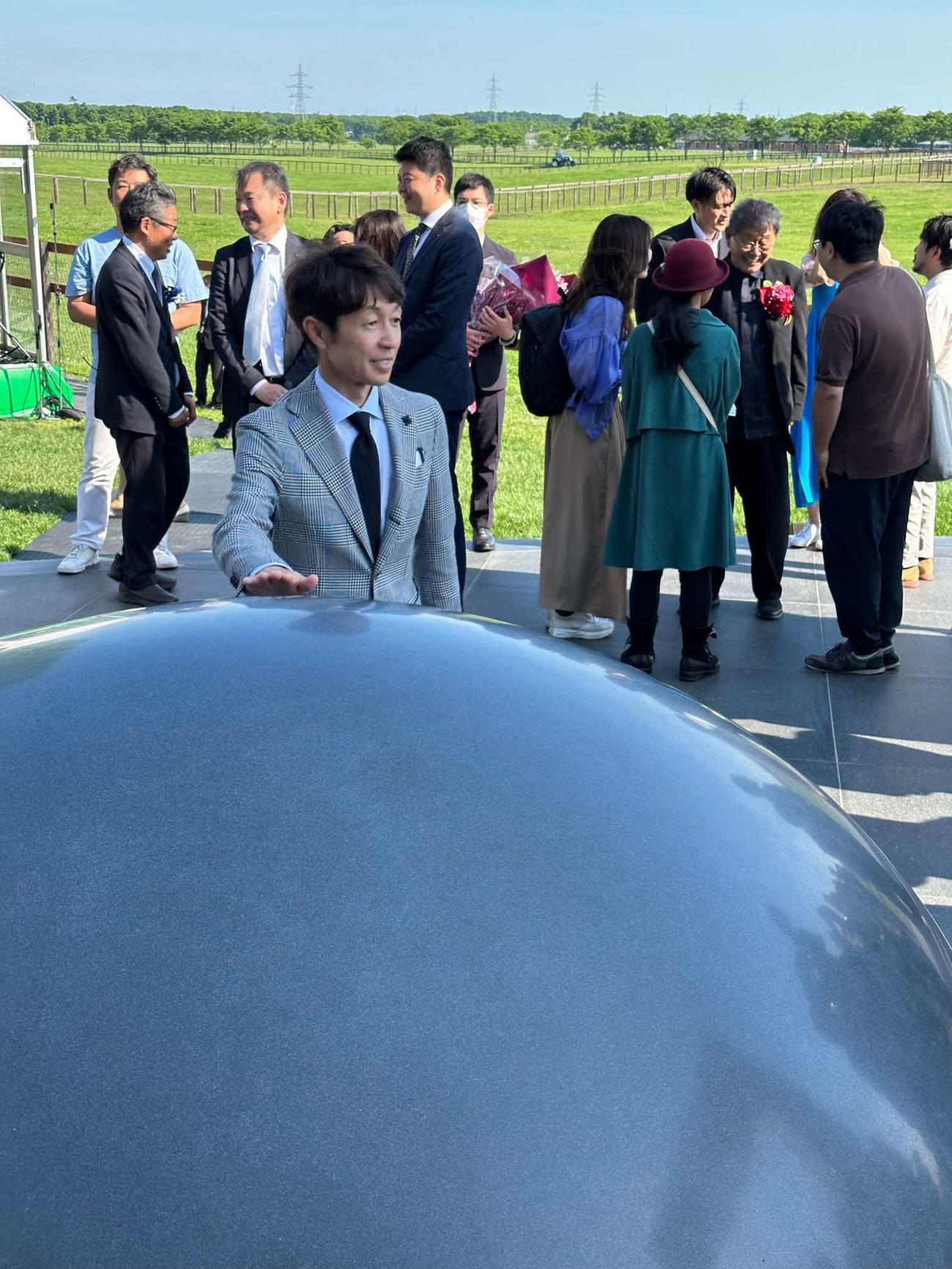 ディープインパクトゲートのモニュメント「意心帰」に触れる武豊騎手