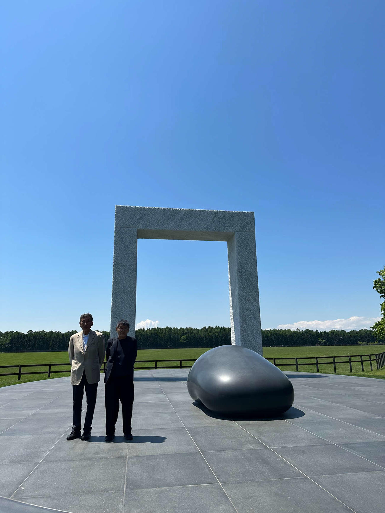 ディープインパクトゲートと写真に収まるノーザンホースパーク吉田勝己社長（左）と彫刻家の安田侃氏