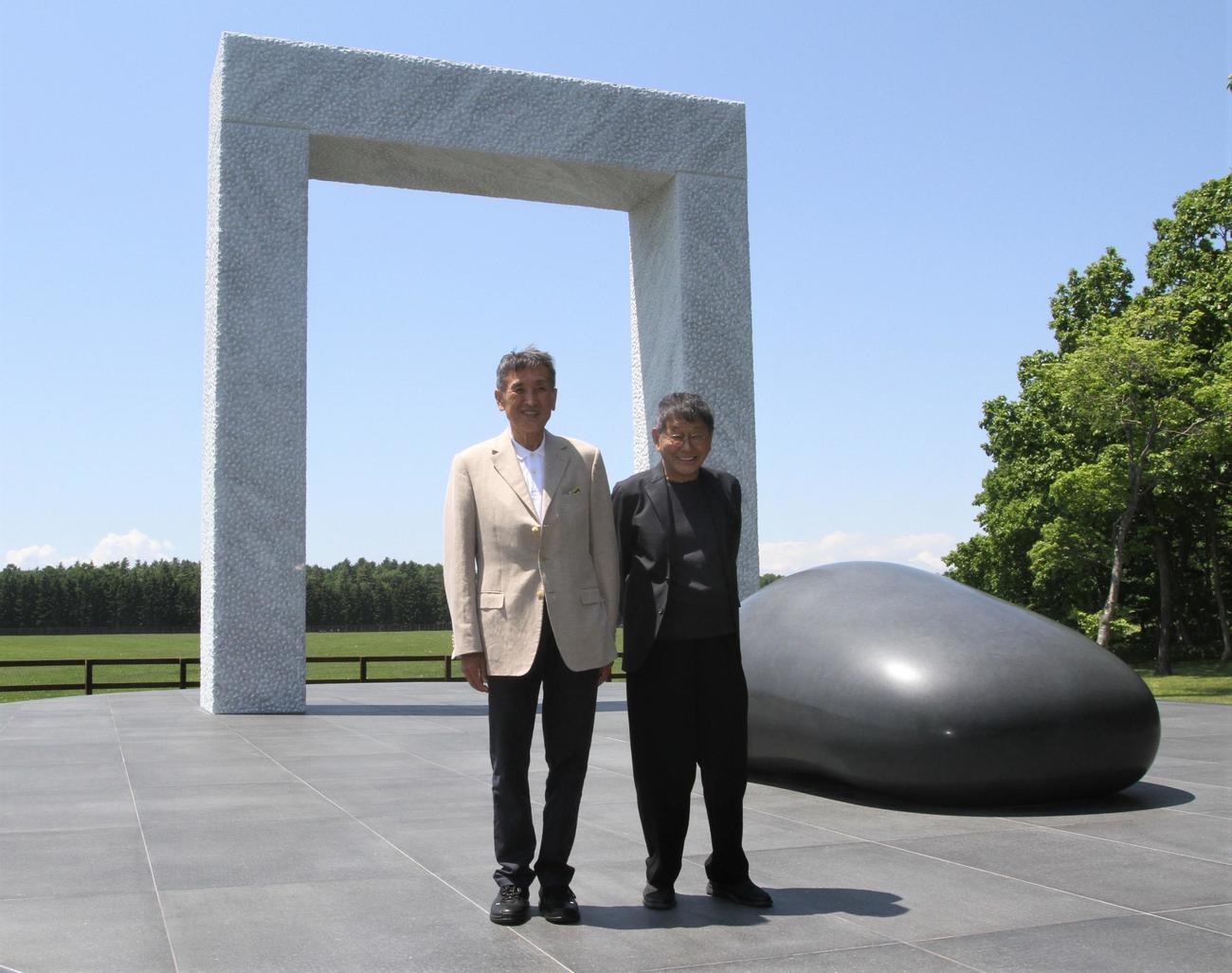 ディープインパクトゲートとともに写真に収まるノーザンホースパーク吉田社長（左）と彫刻家の安田氏