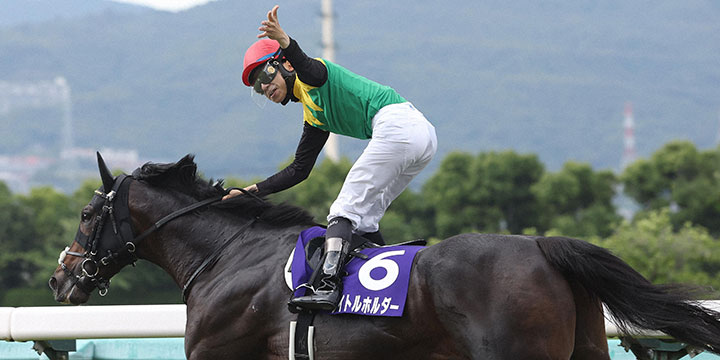 タイトルホルダーで宝塚記念を制し、左手を広げて勝利をアピールする横山和騎手（撮影・白石智彦）＝2022年6月26日、阪神競馬場