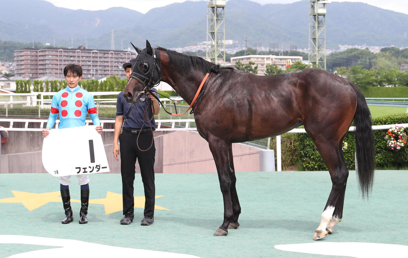 阪神1R、2歳未勝利を勝ち上がったフェンダーと口取りに並ぶ坂井騎手（左）（撮影・白石智彦）