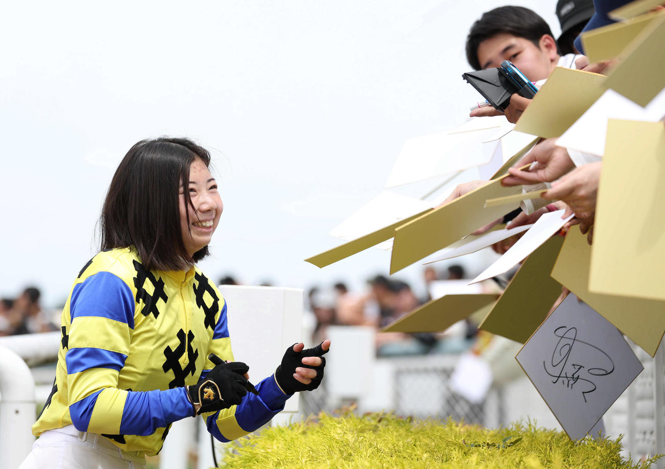 阪神7R、プリマヴィータで復帰後初勝利を挙げファンに笑顔でサインする河原田騎手（撮影・白石智彦）