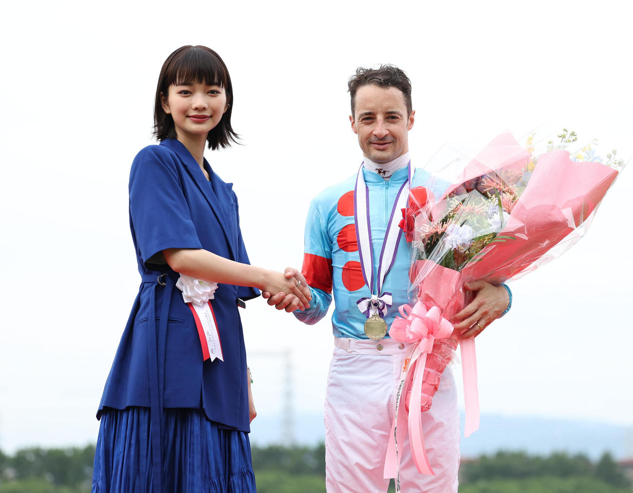 表彰式で握手するプレゼンターの見上愛（左）とC・ルメール騎手（撮影・白石智彦）