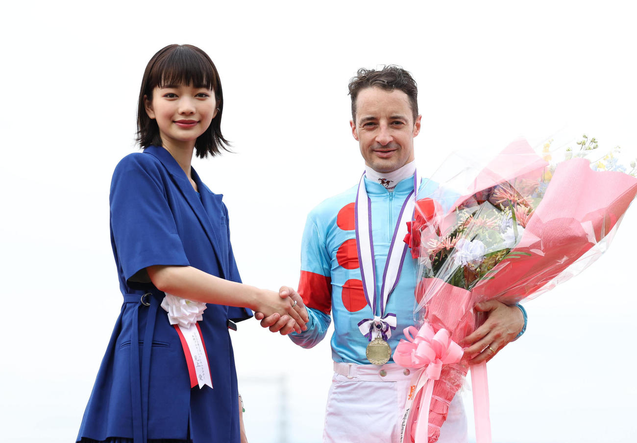 宝塚記念の表彰式で握手するプレゼンターの見上愛（左）とC・ルメール騎手（撮影・白石智彦）