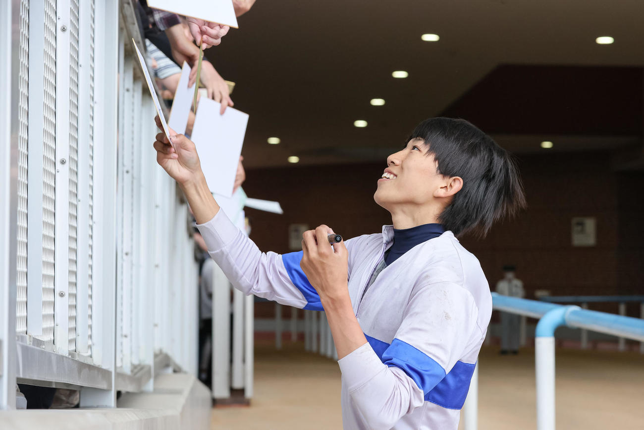 ファンにサインする鷲頭騎手（撮影・村野早祐）