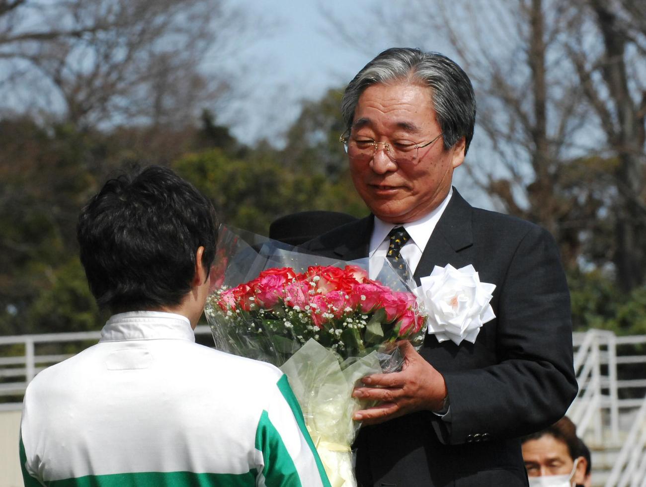 引退式でおいの横山典弘騎手から花束を贈られる奥平真治調教師（07年2月25日撮影）