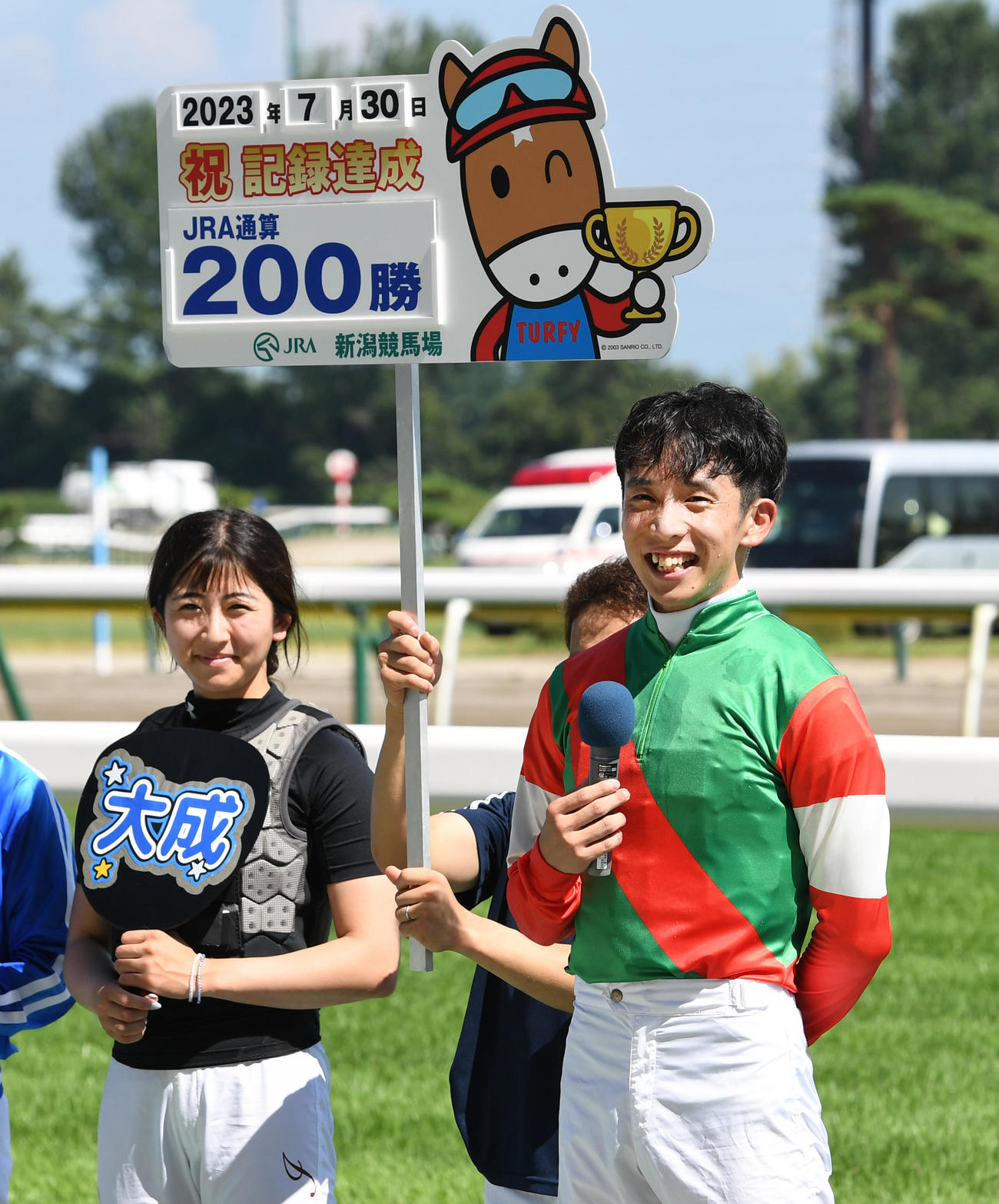 スペシャルナンバーでJRA200勝を達成した団野大成騎手は笑顔を見せる。左は今村聖奈騎手