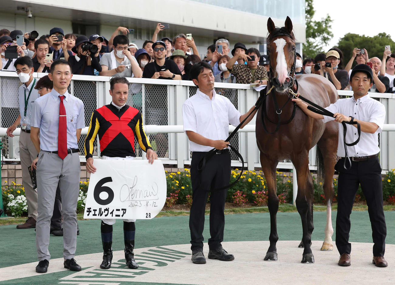2歳未勝利戦を制したチェルヴィニアの口取りをする木村師（左）とルメール騎手（撮影・丹羽敏通）
