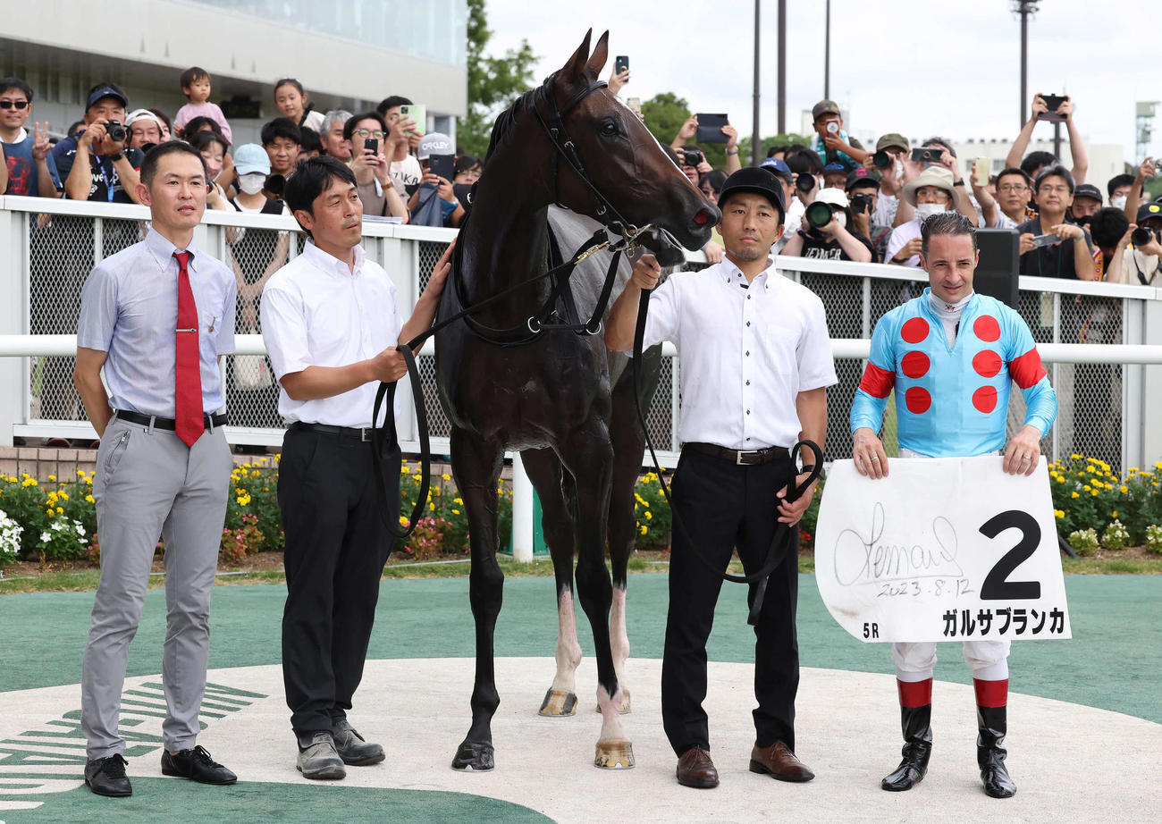 新潟5R、2歳新馬戦を制したガルサブランカの口取りをする木村師（左）とルメール騎手（撮影・丹羽敏通）