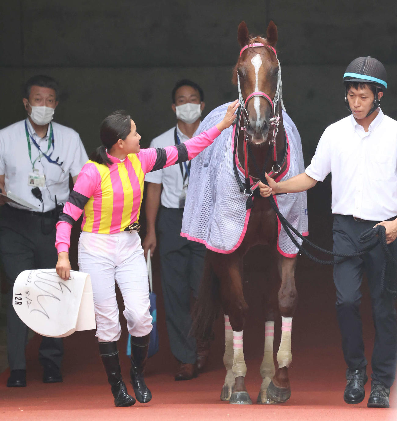 キュートヘスティアの顔をなでてねぎらう小林美駒騎手（撮影・丹羽敏通）