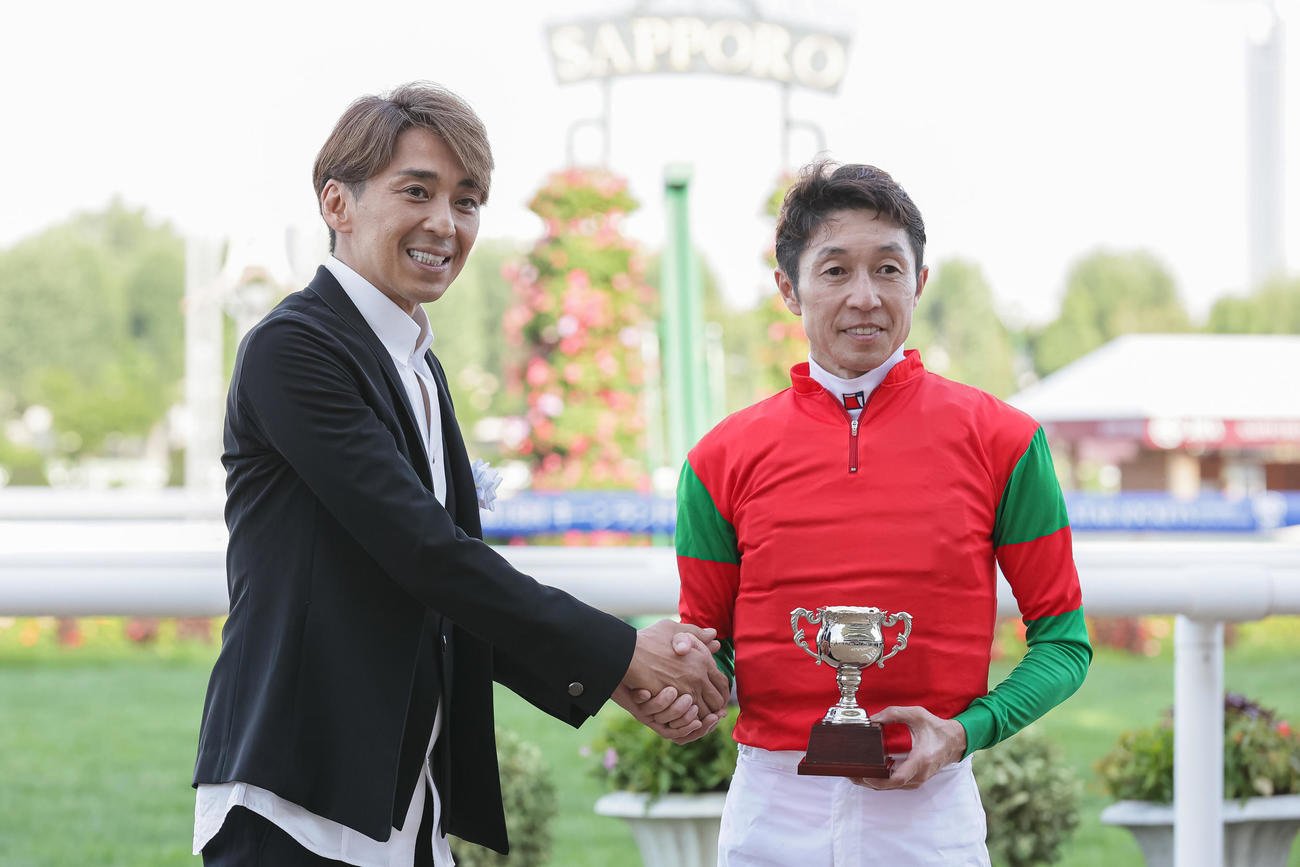 ゲストプレゼンターの森且行（左）と笑顔で握手する武豊騎手（撮影・村野早祐）