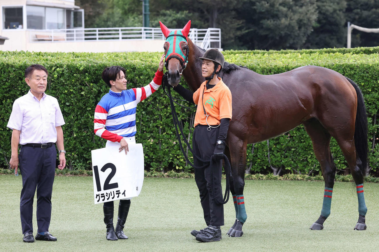 中山4R新馬戦を制したグラシリティの口取りをする相沢師と石川騎手（撮影・丹羽敏通）