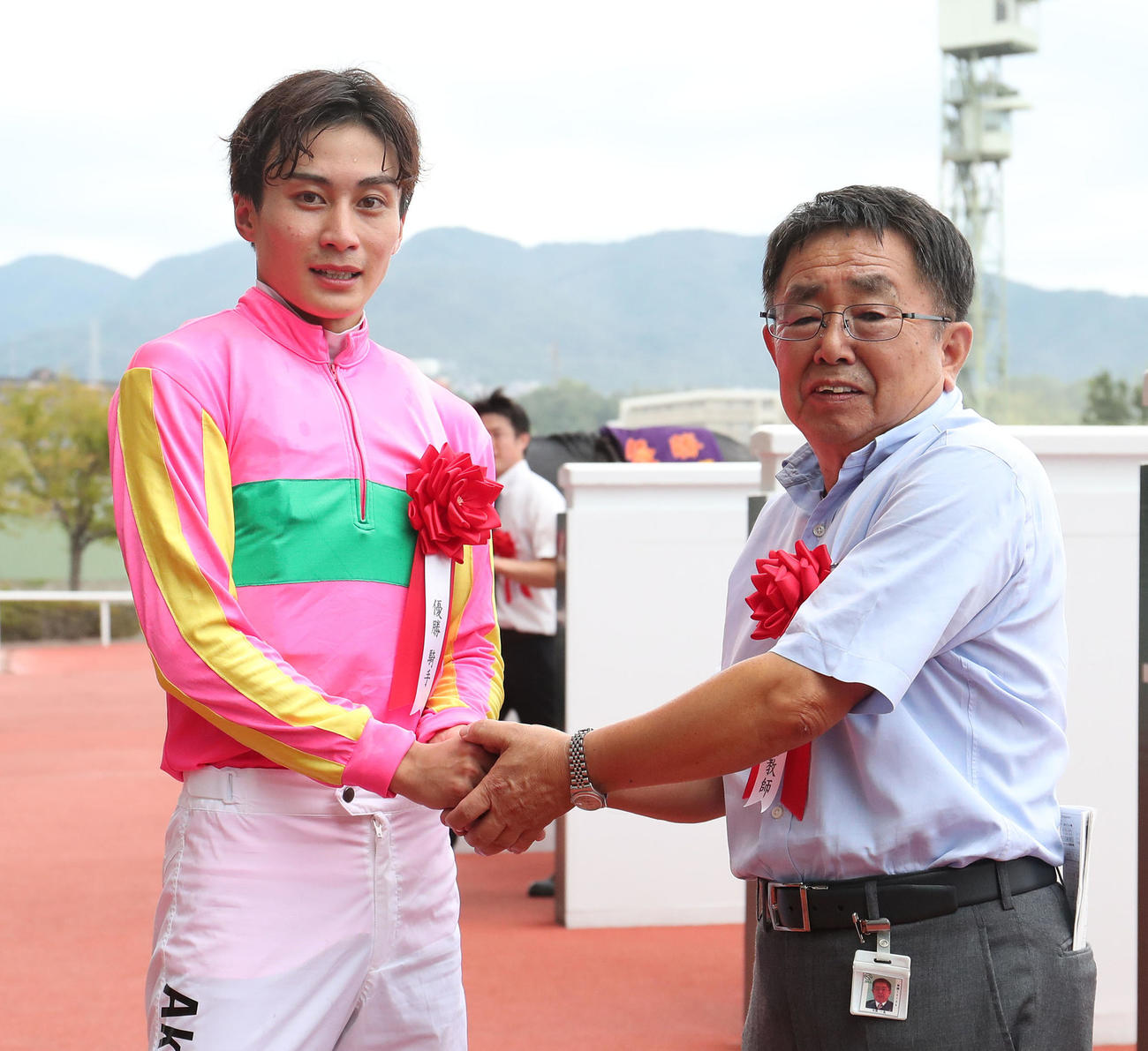 握手を交わす重賞初制覇の富田騎手（左）と師匠の木原師（撮影・白石智彦）
