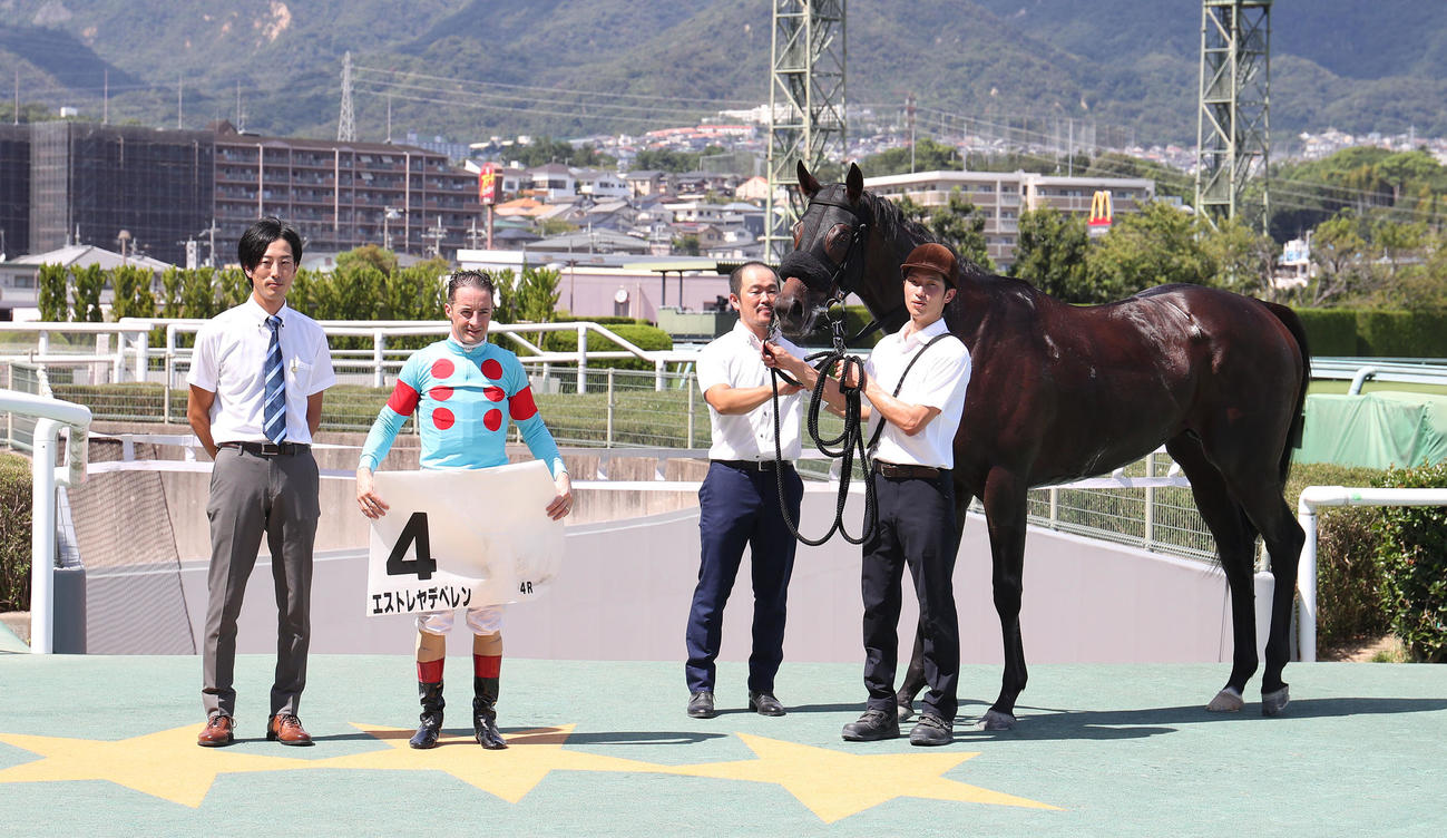 阪神4R、新馬戦を快勝したエストレヤデベレンと口取りに並ぶC・ルメール騎手（左から2人目）