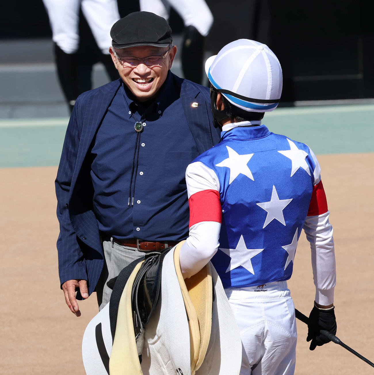 中山7R、管理馬最後のレースに騎乗した大野騎手を迎える勇退する浅野師（撮影・丹羽敏通）