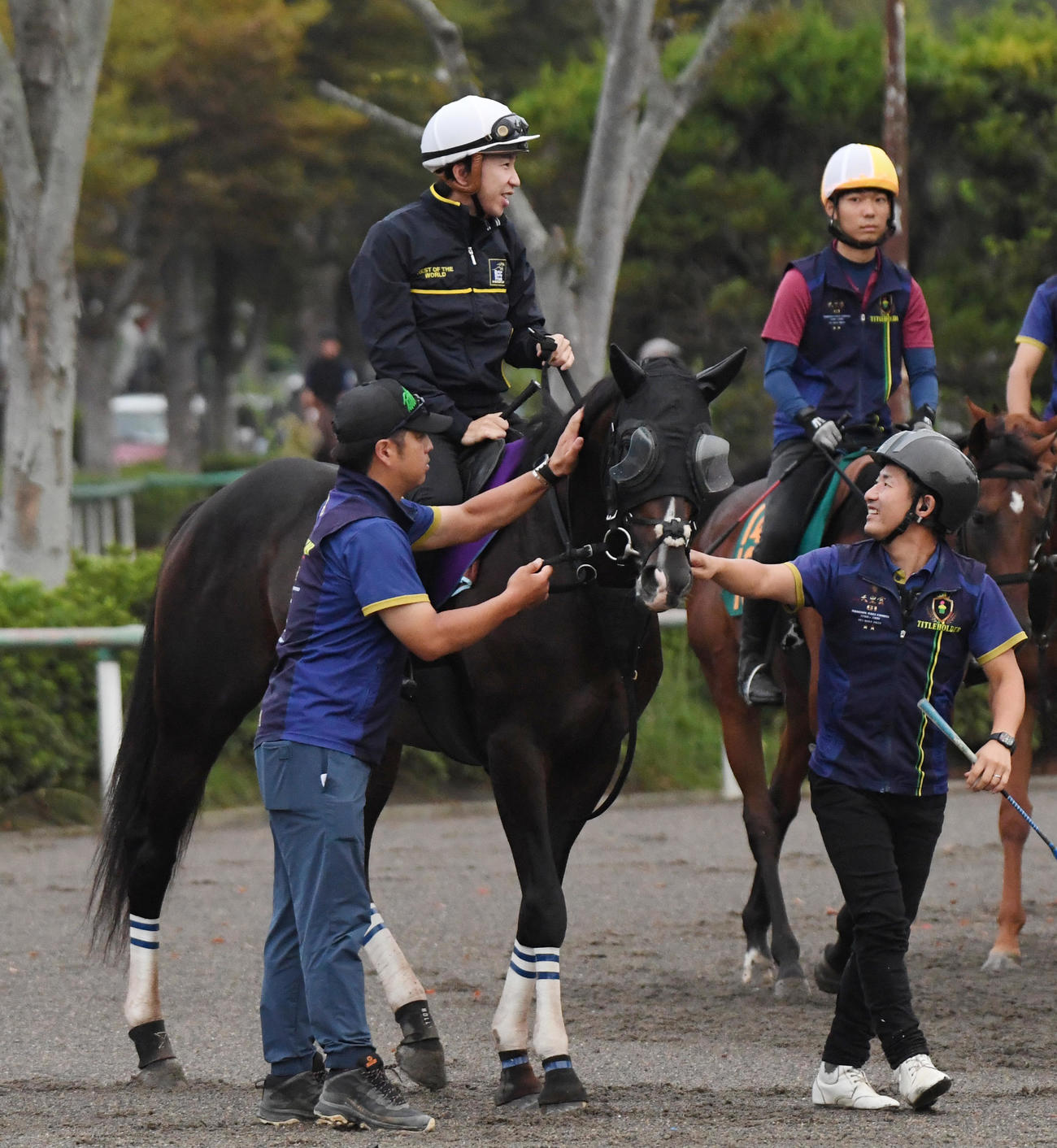横山和騎手を背にタイトルホルダーは調教に向かう。左は栗田調教師（撮影・柴田隆二）