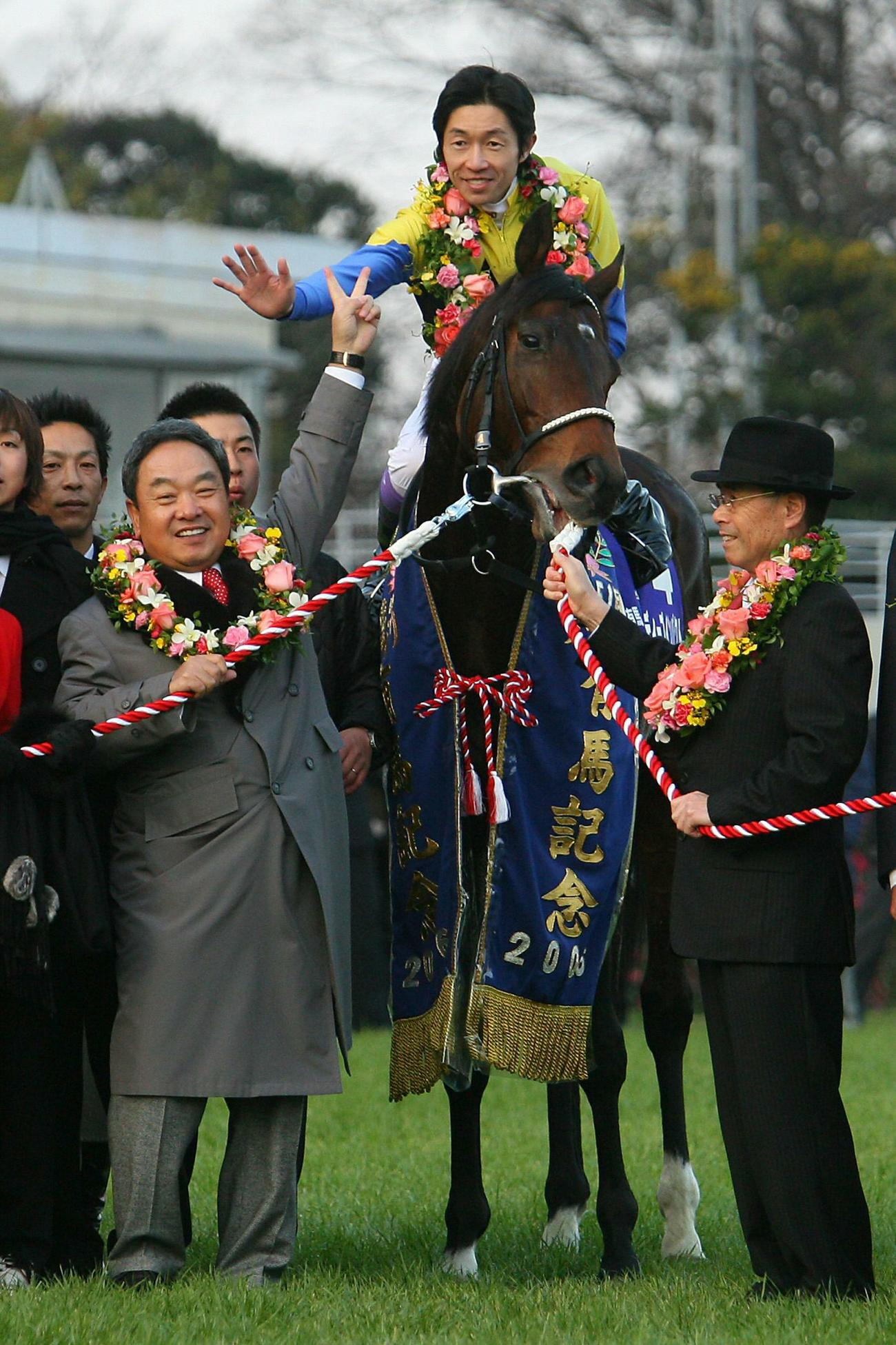 06年、ディープインパクトは有馬記念も制し7冠とした武豊騎手は金子真人オーナー（左）と「7」のポーズ