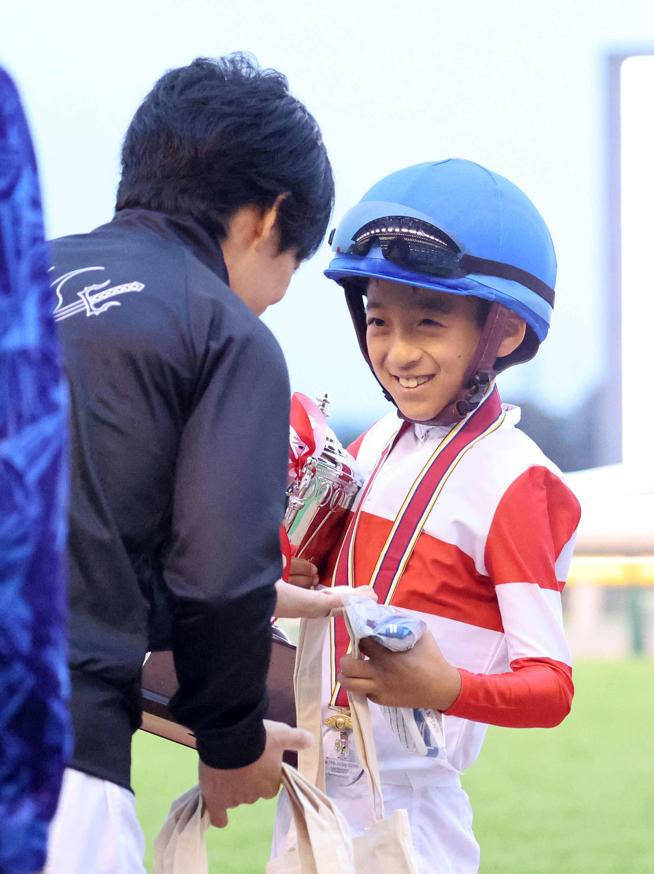 父の川田将雅騎手（左）から記念品をもらい笑顔を見せる川田純煌選手（撮影・鈴木正人）