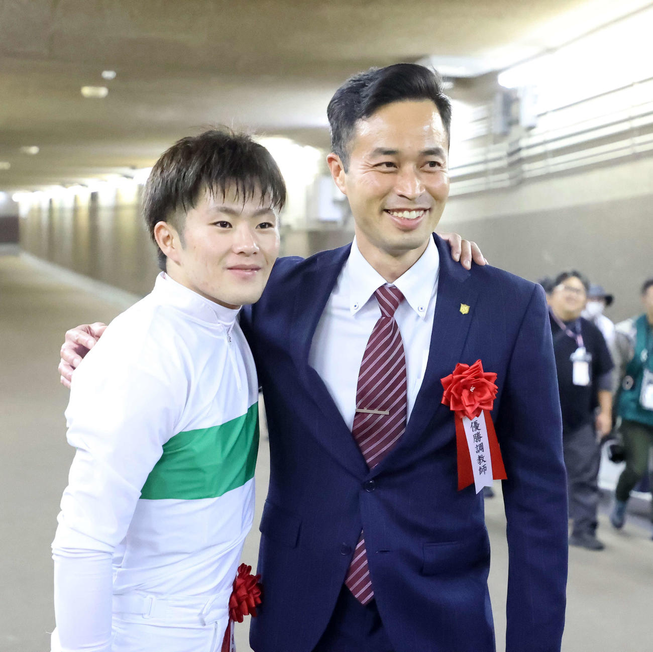 肩を組み笑顔を見せる西村淳也騎手（左）と杉山晴紀調教師（撮影・鈴木正人）