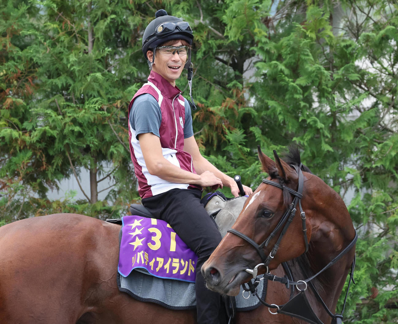 リバティアイランドの馬上で笑顔を見せる片山助手（撮影・白石智彦）