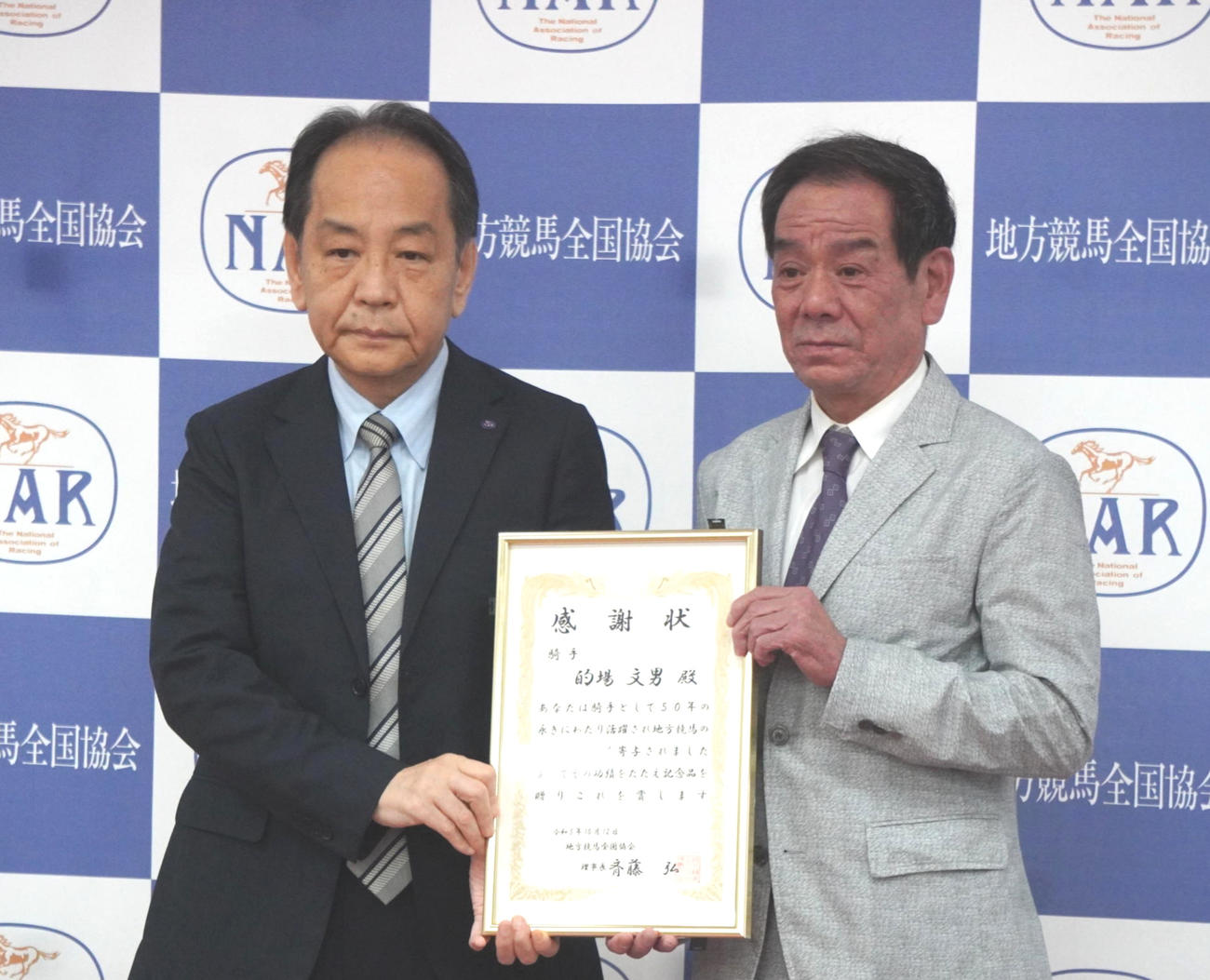 感謝状を贈呈される的場文男騎手（右）と斉藤弘地方競馬全国協会理事長