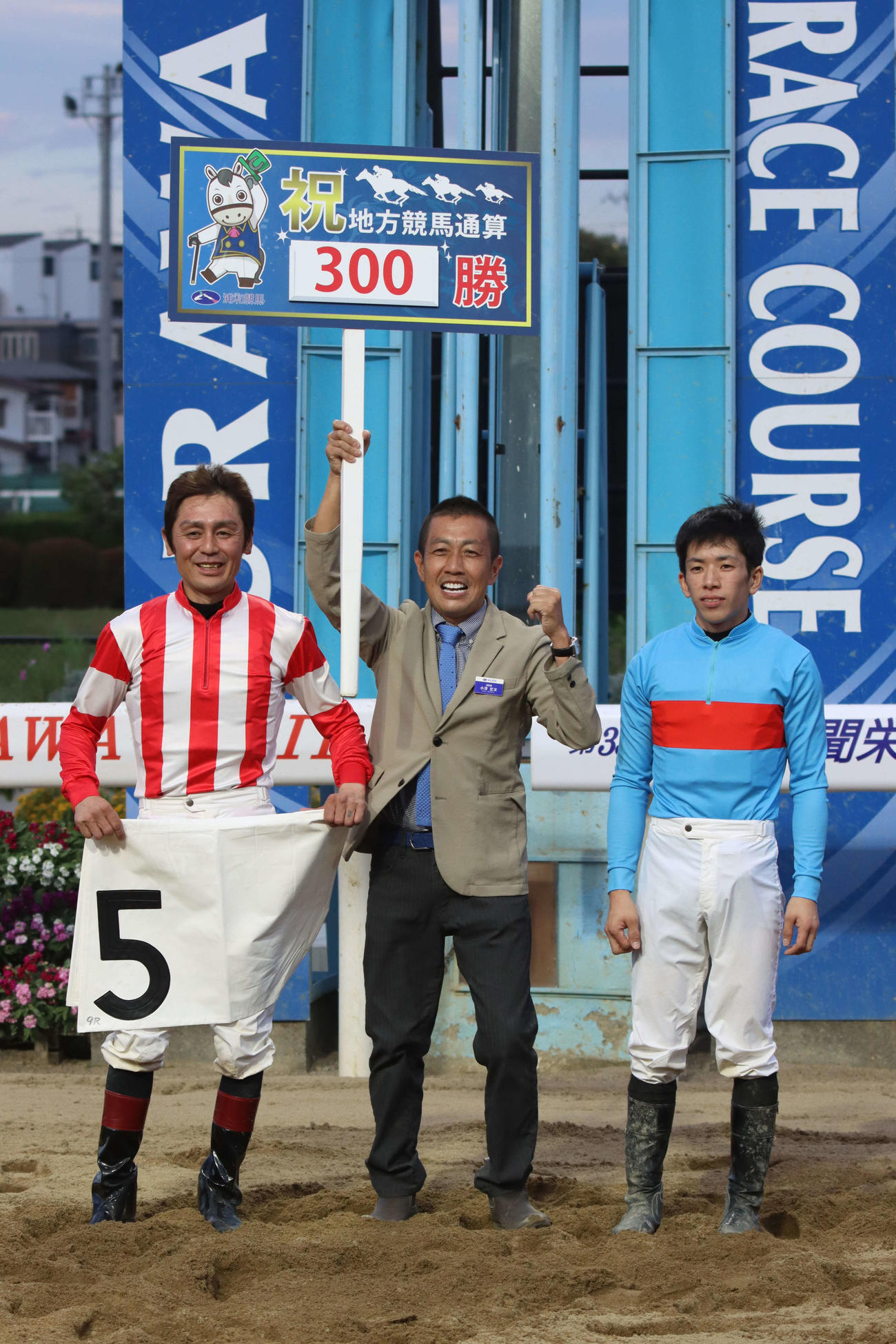 浦和9Rで地方競馬通算300勝を達成しプラカードを掲げる浦和の小沢宏次調教師（中央）