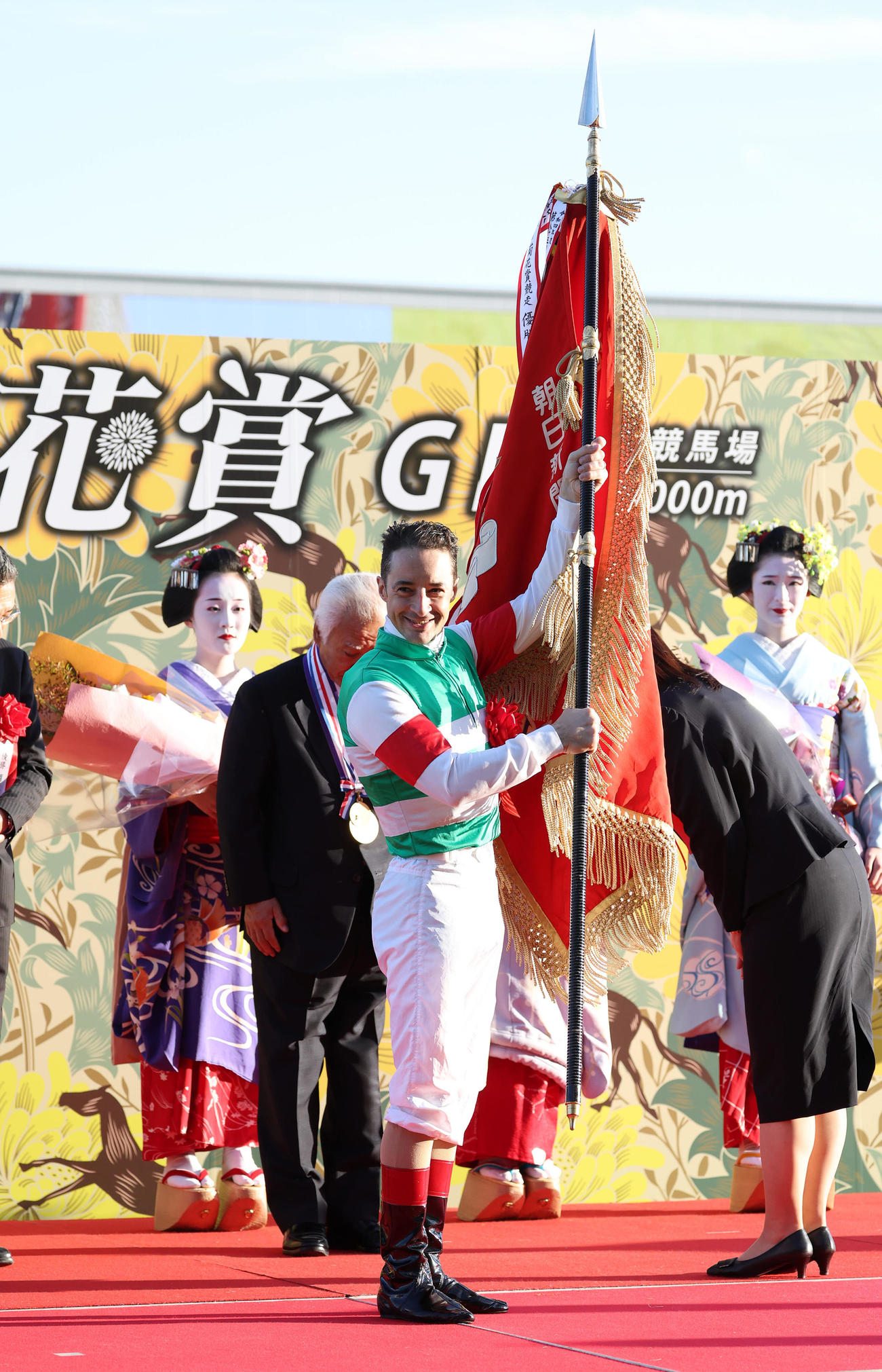 優勝旗を掲げるC・ルメール騎手（撮影・白石智彦）