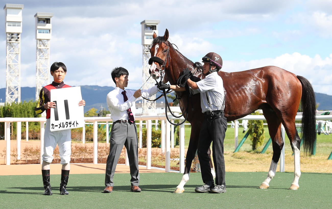 京都5R、新馬戦を制したカーメルタザイトと口取りに並ぶ北村友騎手（左）（撮影・白石智彦）