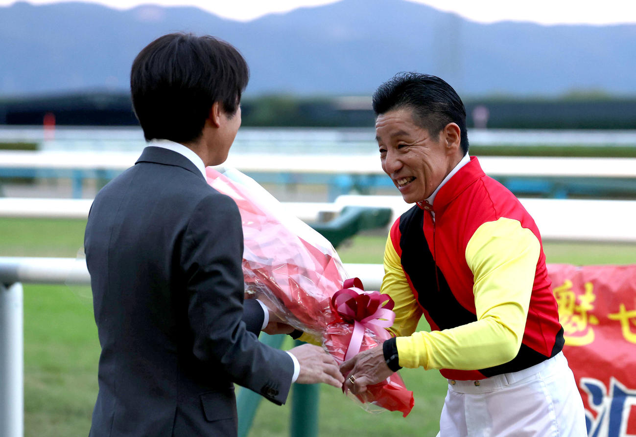 引退式で熊沢騎手（右）に花束を渡す競馬学校同期の松永幹師（撮影・白石智彦）